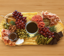 Load image into Gallery viewer, Charcuterie board with meats, cheeses, fruits, and pickles on a wooden surface